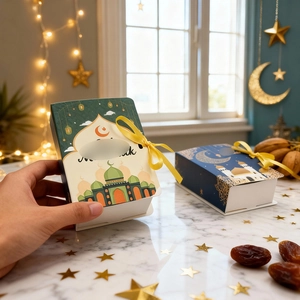 Detail of Ramadan book-shaped candy boxes with mosque patterns and gold ribbons