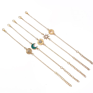 Close-up of a 5-piece gold bracelet set with moon, star, and rhinestone charms