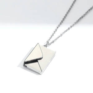 Macro shot of a silver titanium steel envelope locket pendant showing hinged opening detail