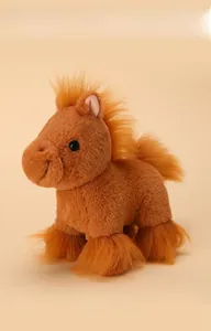 Detail of soft brown plush pony toy with bright orange mane and fluffy tail texture