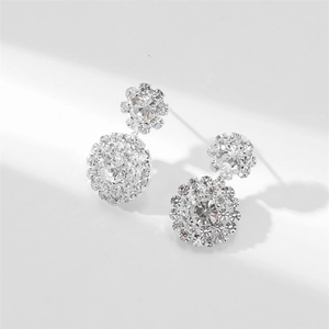 Macro shot of silver snowflake earrings with sparkling zirconia clusters on white background