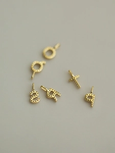 Detailed view of 14K gold plated S925 silver letter pendants with dot-patterned texture