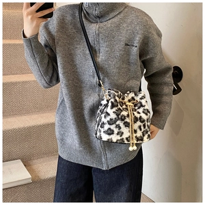 Detail of leopard print faux fur bucket bag with golden chain and drawstring closure