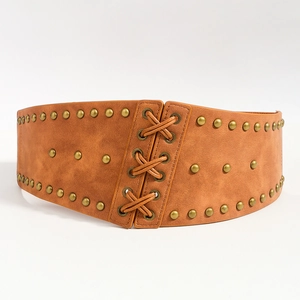 Detail view of a brown suede corset belt featuring bronze rivets and lace-up design