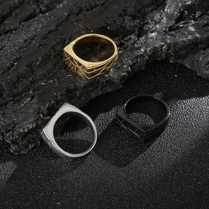 Macro view of geometric patterned rings in gold, silver and black on stone background
