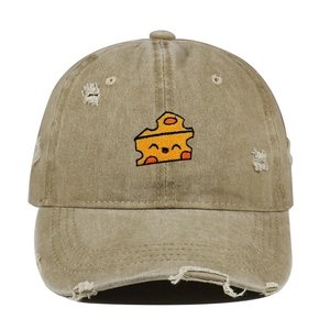 Close-up of khaki washed baseball cap featuring cheese embroidery and distressed details