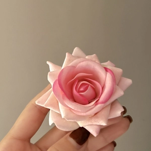 Close-up of pink and white gradient rose hair clip with realistic layered petals