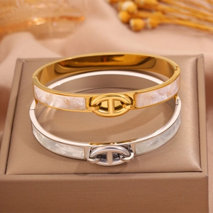 Macro detail of gold and silver steel bangles with shell inlay and pig nose buckle