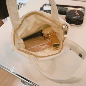 Vista dall'alto di una borsa bianca trapuntata con zip che mostra lo spazio interno