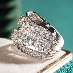 Macro detail of silver wide band ring with crisscross cubic zirconia patterns
