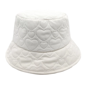 Detailed view of white corduroy bucket hat with heart quilted texture and warm fabric