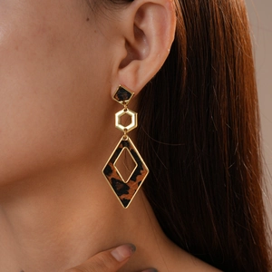 Close-up of leopard print geometric drop earrings featuring square and diamond shapes