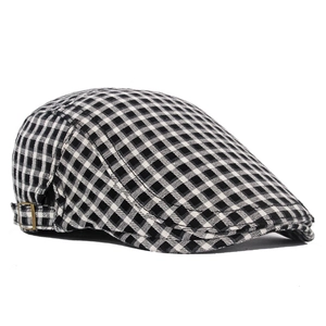 Close-up of black and white checkered beret with a bronze metal adjustment buckle