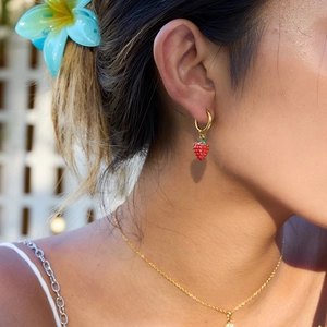 Close-up of model wearing 18K gold plated strawberry drop earrings in natural light