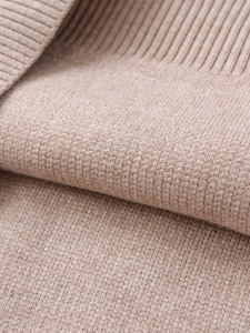 Macro detail of oatmeal knitted fabric showing fine texture and ribbed stitching quality