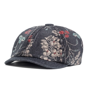 Detailed view of floral print on washed denim fabric of a vintage newsboy cap