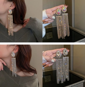 Detail view of long tassel earrings with pear-shaped rhinestones and silver tassels