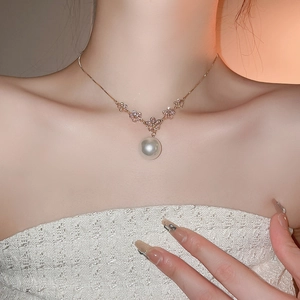 Elegant pearl choker necklace with zircon flowers on rose gold chain worn by a model