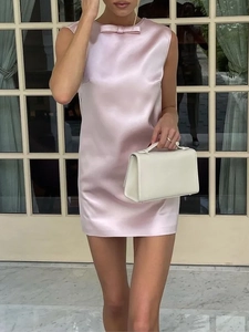 Détail de la mini-robe en satin rose sans manches avec un nœud délicat sur l'encolure