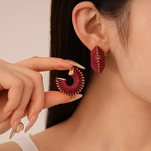 Maillard style faux leather woven C-hoop earrings with gold beads on female model