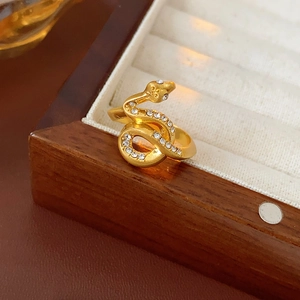 Close-up of gold-plated snake ring with pavé sparkling diamonds on a jewelry box