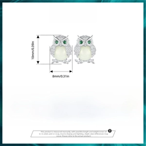 Detailed view of luminous owl stud earrings in 925 silver with green gemstone eyes
