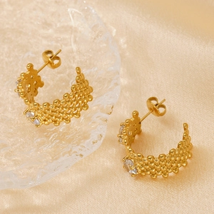 Gold textured J-hoop earrings with sparkling cubic zirconia on elegant satin background