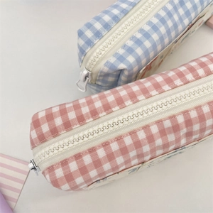 Detail view of light blue and pink gingham pencil cases with smooth white zippers