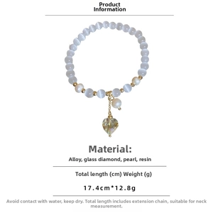 Vue détaillée des perles œil de chat en résine et du pendentif cœur en cristal du bracelet