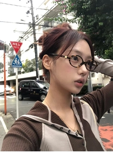 Retro Y2K leopard print oval glasses shown on a model in a trendy outdoor street scene