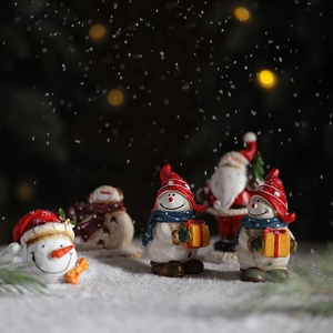 Miniature resin Santa and Snowman Christmas table ornaments in a snowy outdoor scene