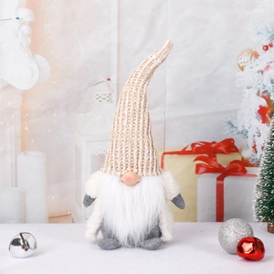 Knitted hat Christmas gnome doll with white beard and festive decor background