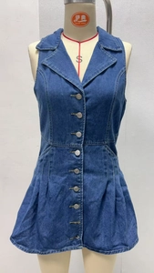 Dettaglio dell'abito in denim con colletto a rever e bottoni in metallo su un manichino