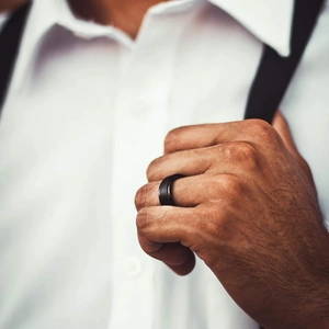 Close-up of a matte black rotating spinner ring with golden inner edge for men