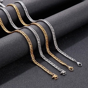 Polished stainless steel curb chain necklaces in gold and silver finishes on a stand