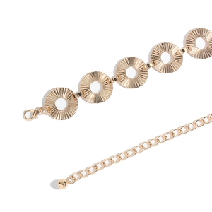 Detail of adjustable gold metal chain belt with sunburst relief rings and lobster clasp