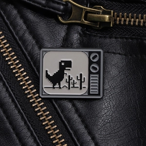 Retro TV metal enamel pin with dinosaur pixel game design on black leather jacket