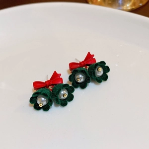 Detail of Christmas earrings featuring red bows, green velvet petals, and white pearls