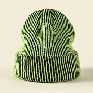 Close-up of the striped knit texture on a neon green and black winter beanie hat