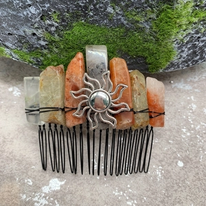 Detail of handmade hair comb with raw natural crystals and a silver sun ornament charm