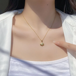 Elegant 925 sterling silver golden fan shell heart pendant necklace worn by a woman