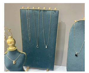 Detailed display of gold necklaces with pendants on navy blue velvet display stands
