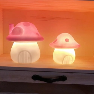 Size comparison of large and small mushroom night lights with warm yellow glow