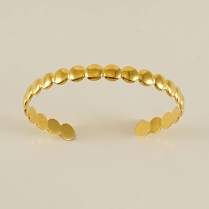 Detailed macro view of 18K gold-plated adjustable open cuff with dot texture design
