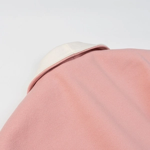 Dettaglio del colletto posteriore del cappotto di lana rosa con fodera bianca e tessuto