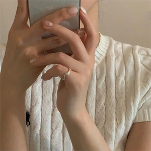 Detail of artistic wavy S925 sterling silver ring on finger with elegant fluid design