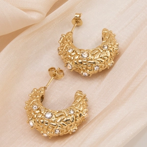 Vue macro de boucles d'oreilles en U plaquées or 18 carats avec texture tressée et zircons