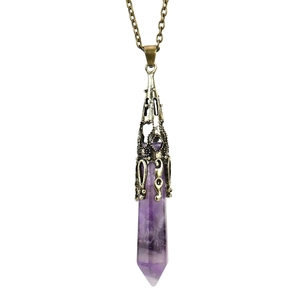 Macro detail of natural amethyst hexagonal pendant with vintage bronze filigree cap