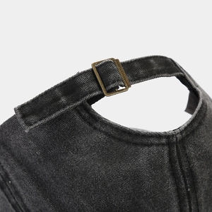 Detail of adjustable metal brass buckle on vintage washed denim baseball cap