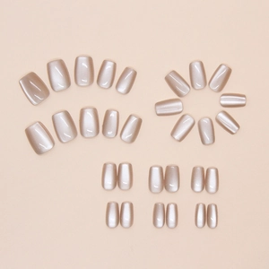 Flat lay of champagne cat eye press-on nails in various sizes for DIY manicure